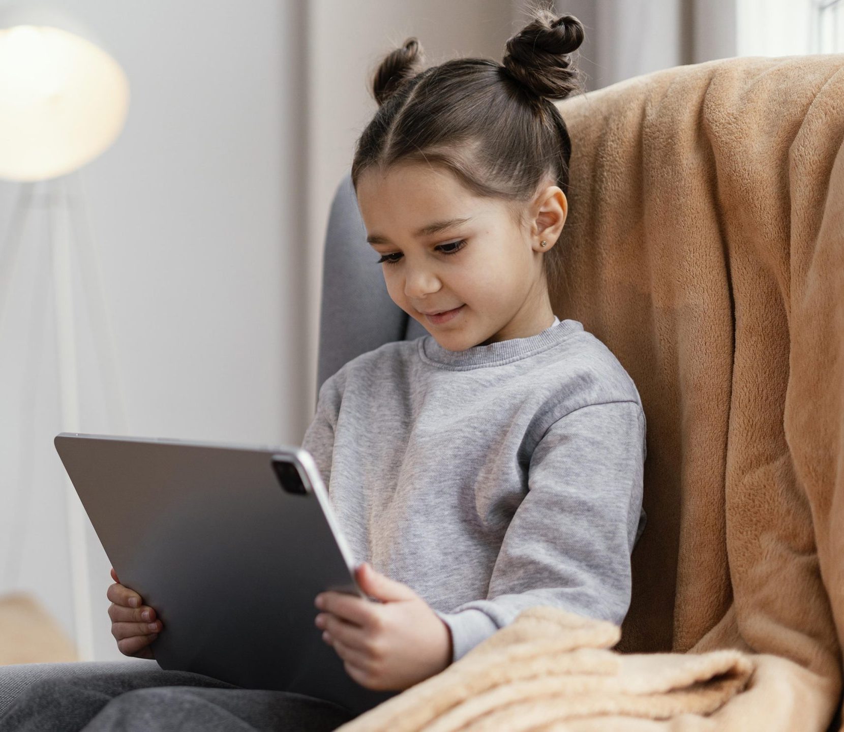 little-girl-couch-using-tablet
